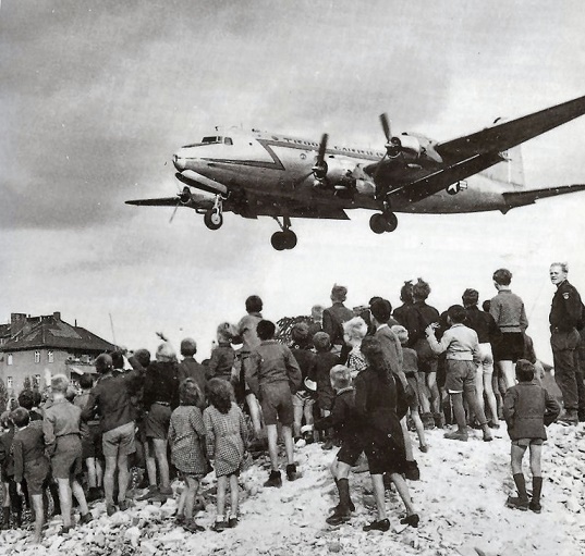 Fotografía que muestra a la gente esperando los suministros que llegaban por avión