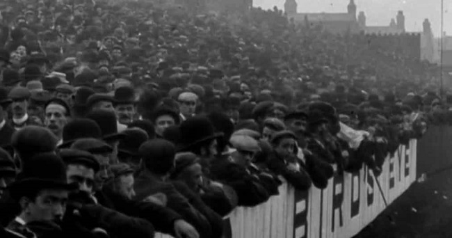 Fotografía de la afición de un partido de fútbol en Anfield en 1901, reflejo de la invención de tradiciones