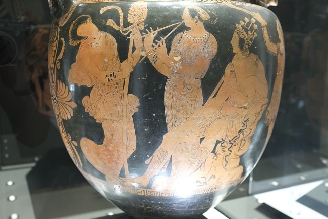 Crátera de figuras rojas en las que se observan a las ménades y a Dionisos posiblemente coronado con cápsulas de adormidera de las que se sacaba el opio en la antigua Grecia