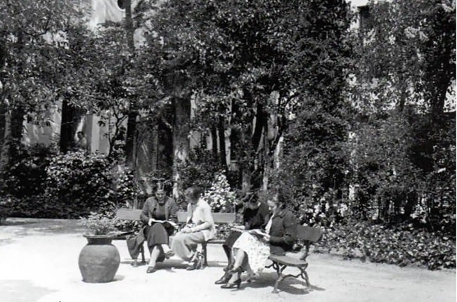 Fotografía del jardín de la Residencia de Señoritas en la que se ve a varias mujeres leyendo